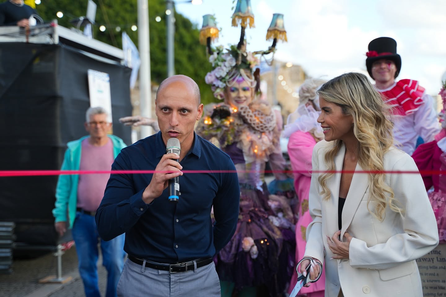 A man speaks into a microphone beside a woman at the festival.