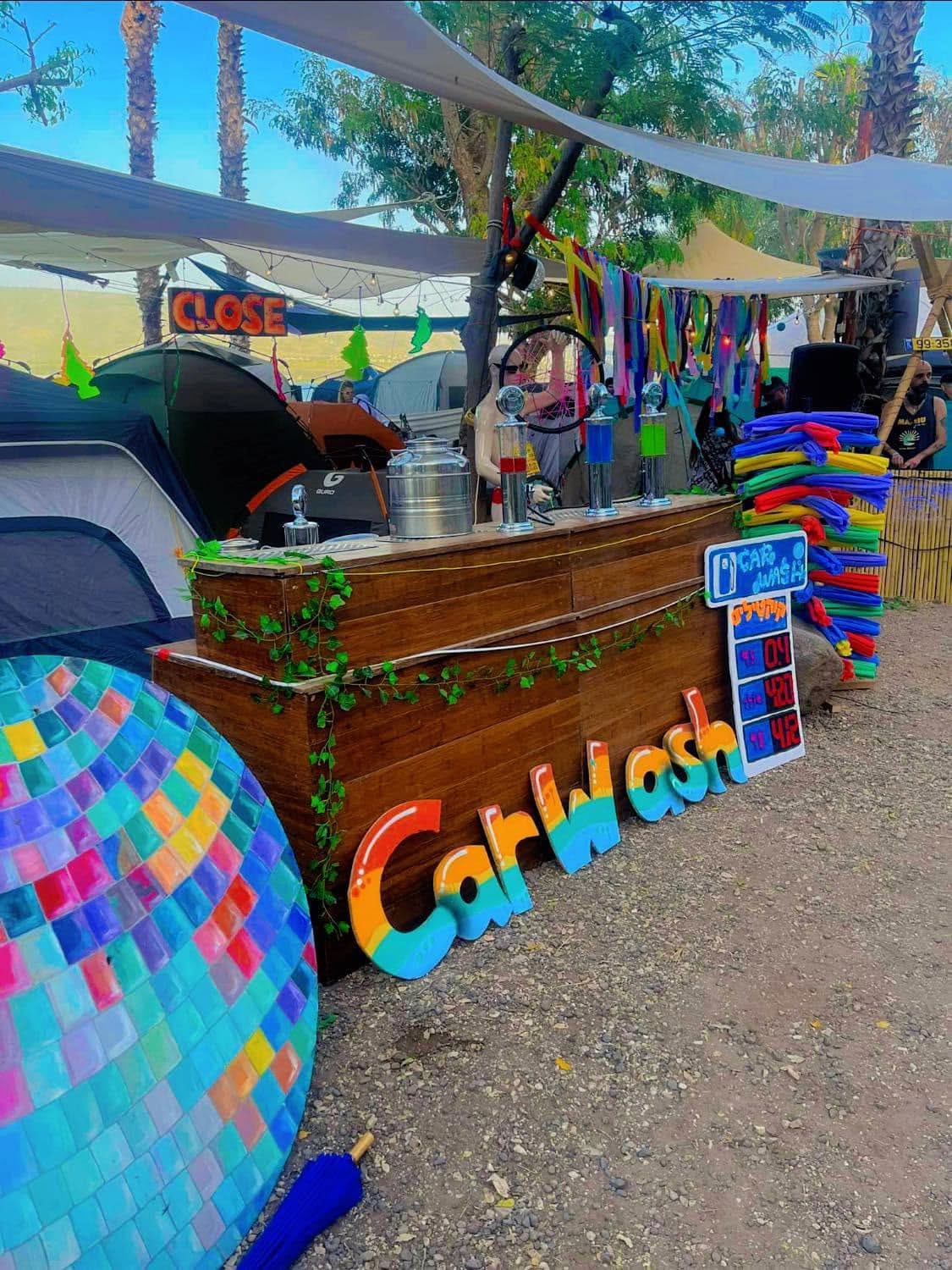 A colourful seating area beneath shade canopies by day.