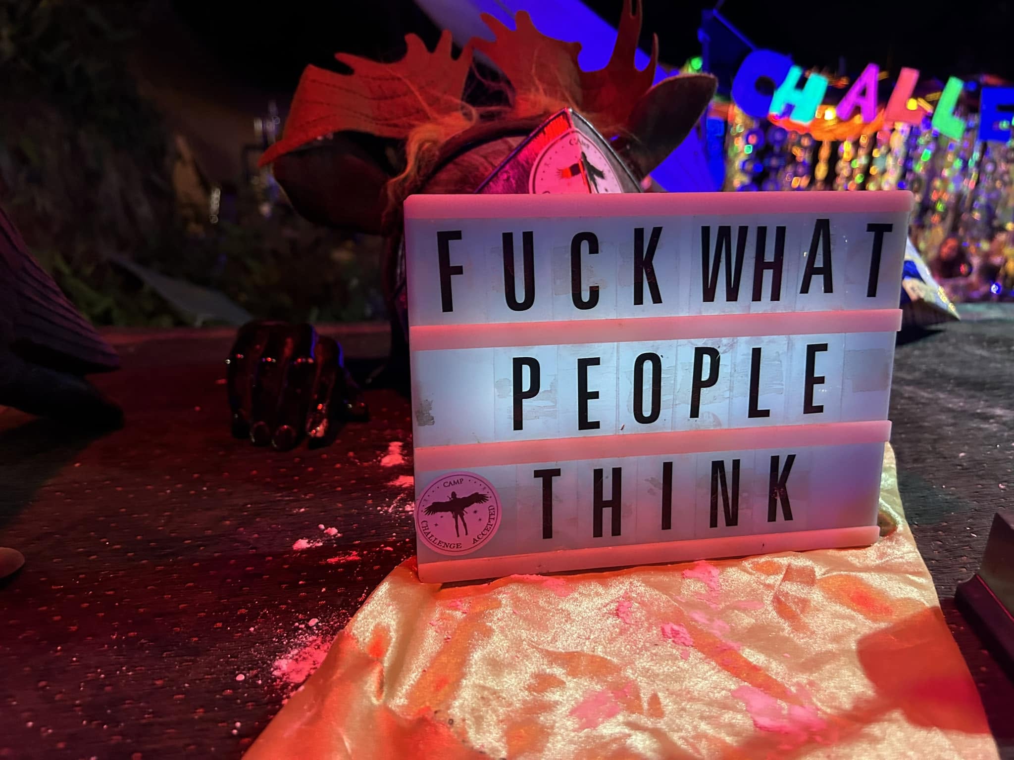 An illuminated sign reads “Fuck What People Think.”