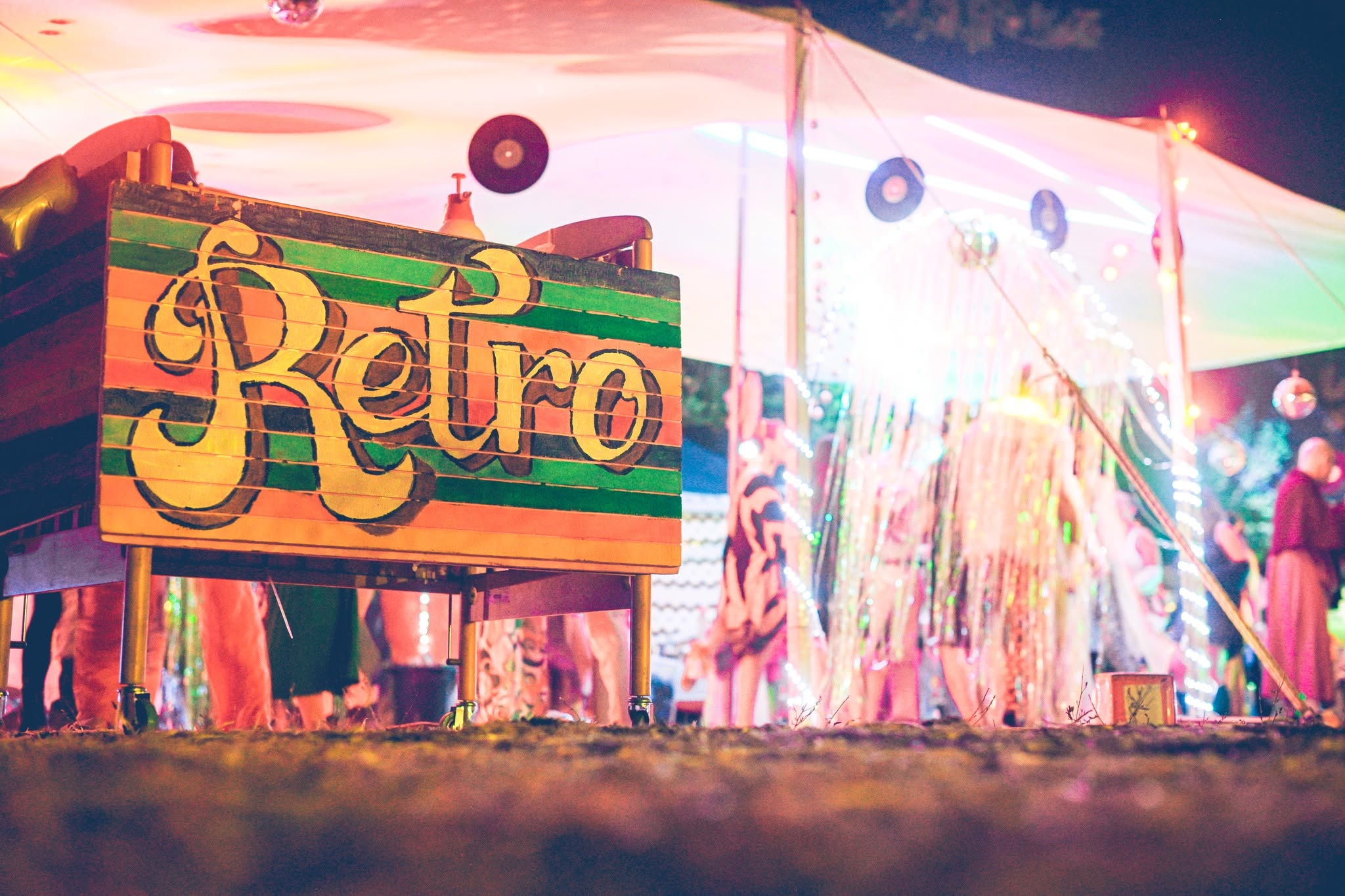 A colourful Retro sign at the entrance to an illuminated space.