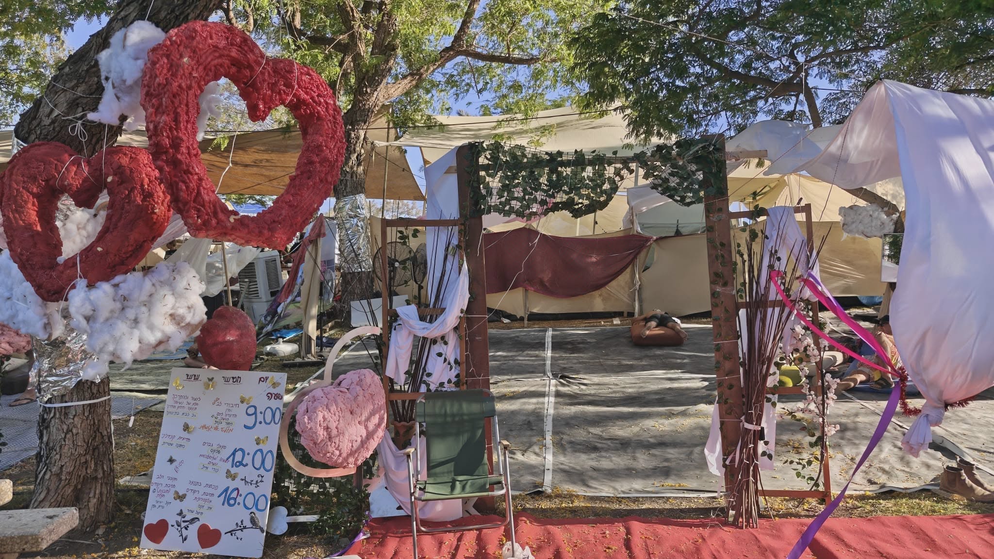 A large red-and-pink heart sculpture beside a seating area.