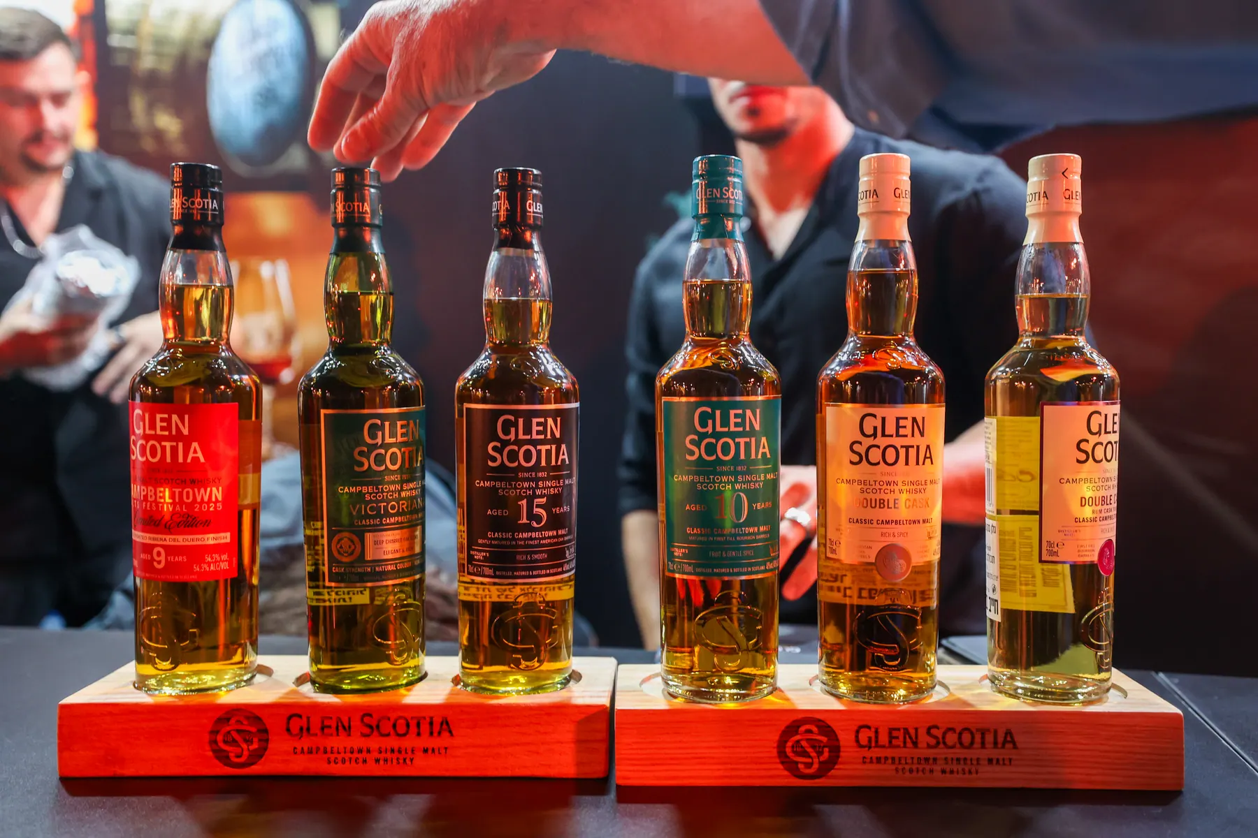 A row of Glen Scotia bottles on a tasting counter.