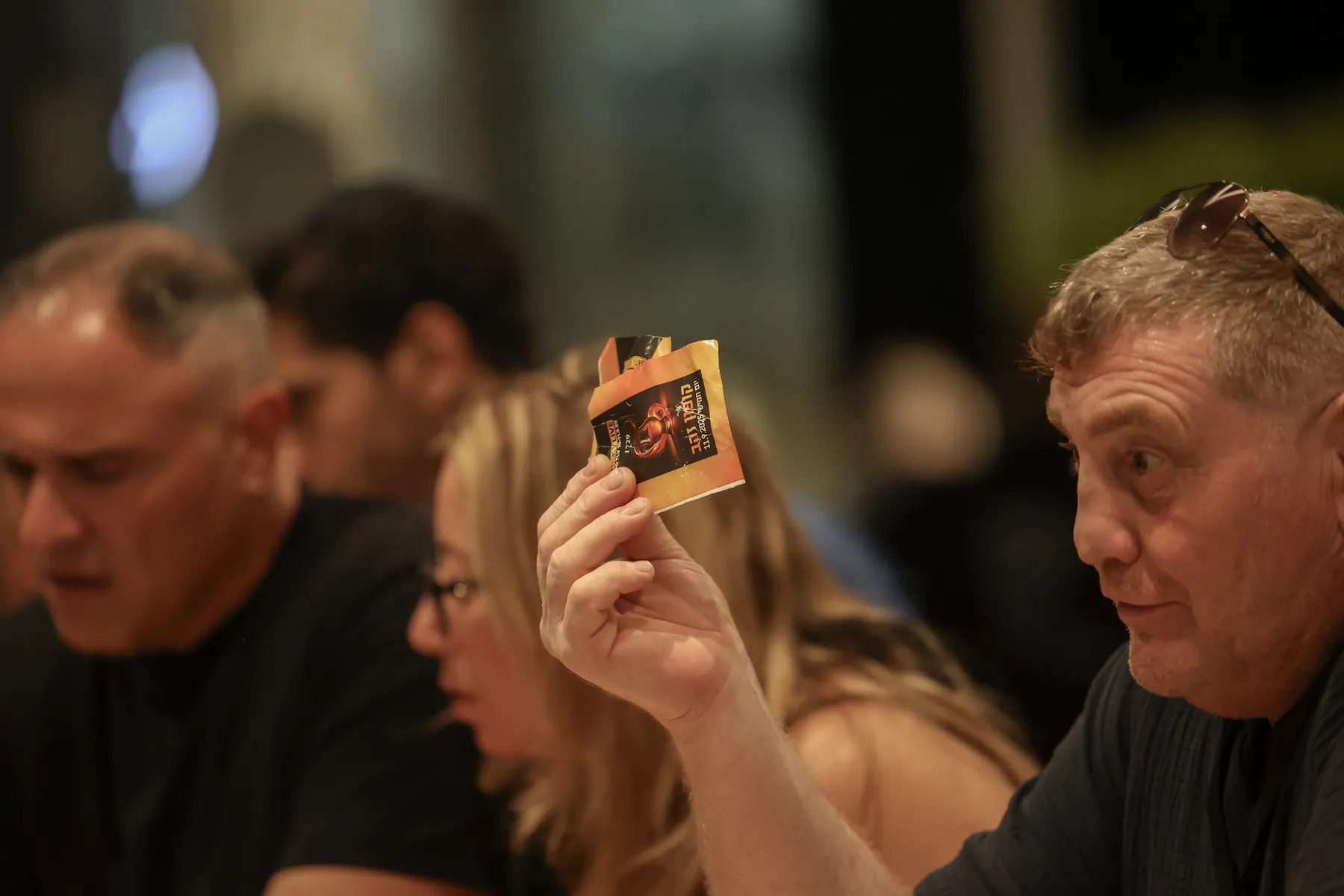 A visitor holds up a card during a tasting.
